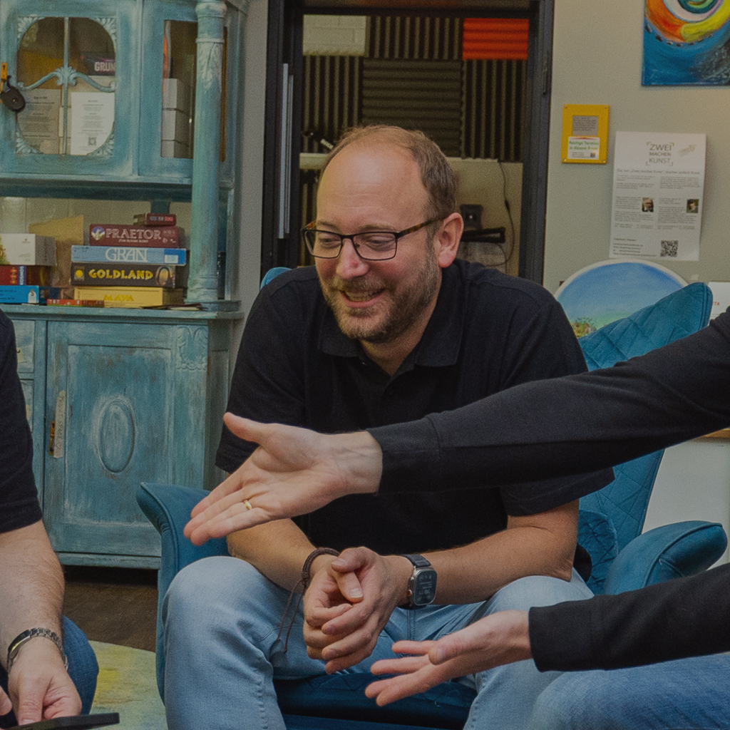 sebastian klöpper sitzt lachend auf einen sessel